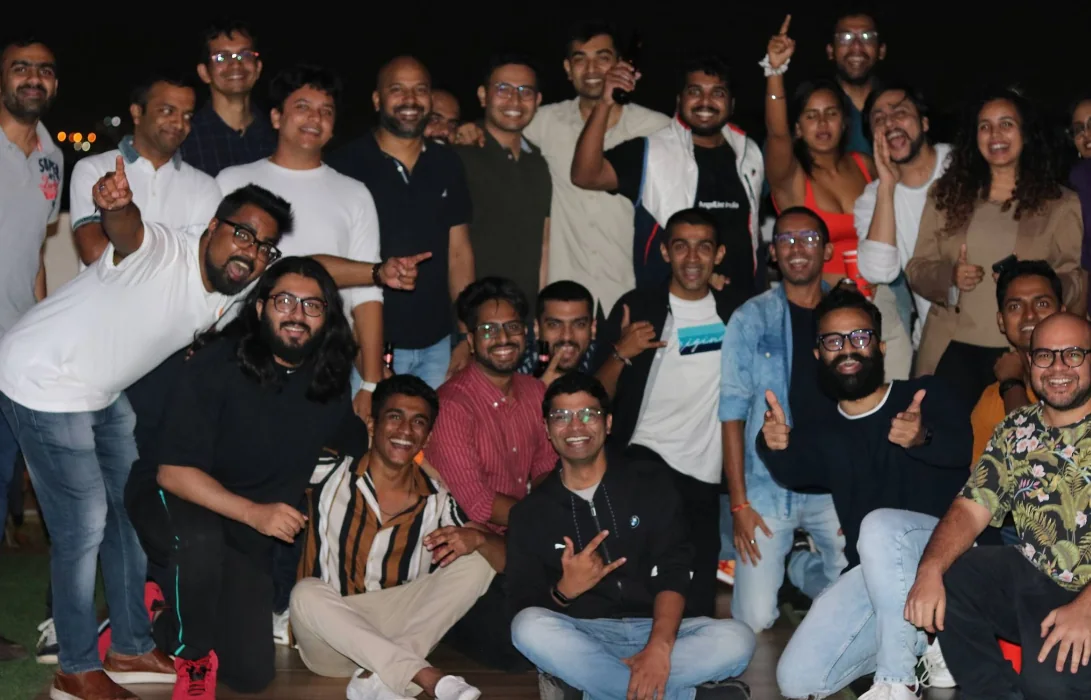 Manipal alumni smiling together in a group photograph at night