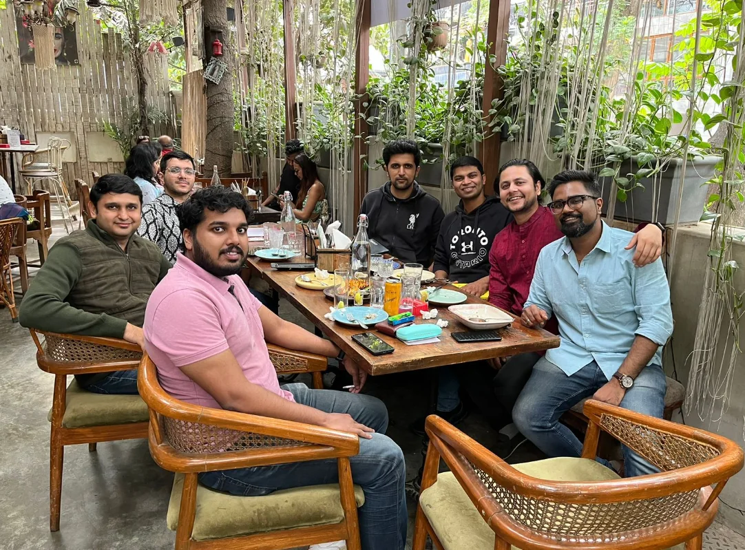 Alumni gathered around a table at a leafy café